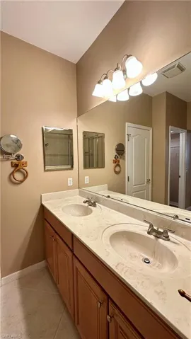 Bathroom featuring double vanity and light tile patterned floors