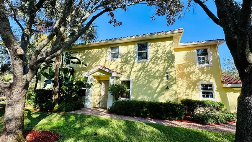 Mediterranean / spanish home with stucco siding, a tile roof, and a front lawn