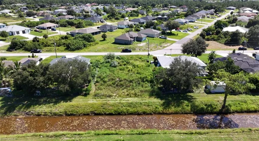 Aerial perspective of suburban area featuring a nearby body of water