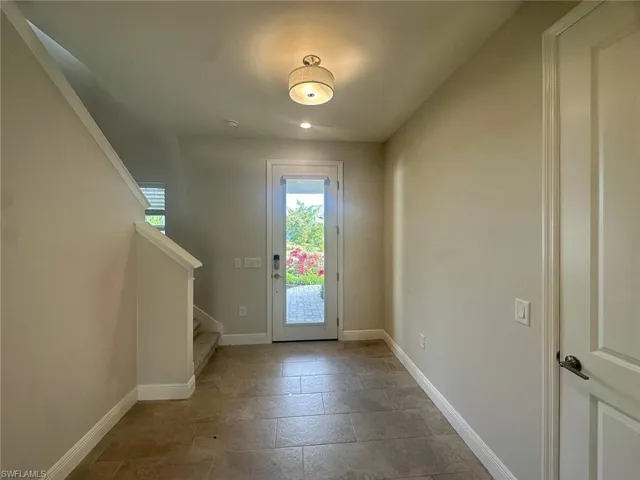 Doorway to outside featuring stairway and stone finish flooring