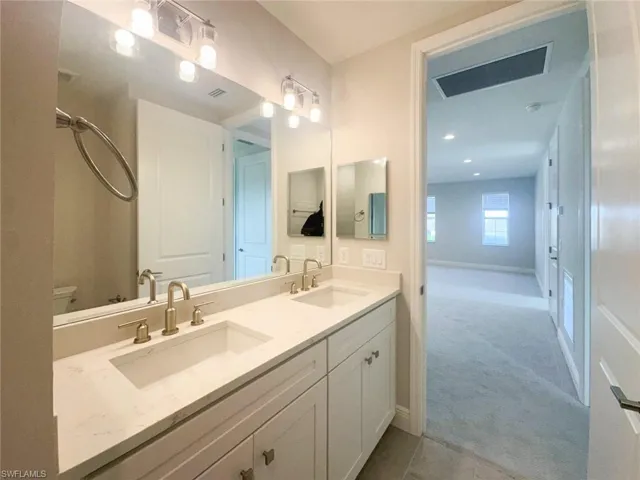 Bathroom featuring light colored carpet and double vanity
