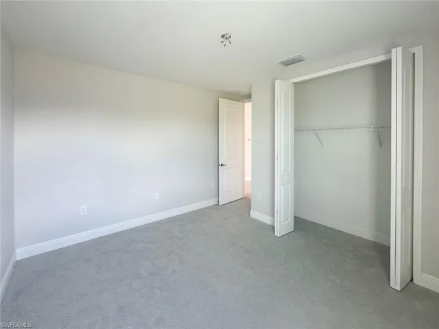 Unfurnished bedroom featuring carpet and a closet