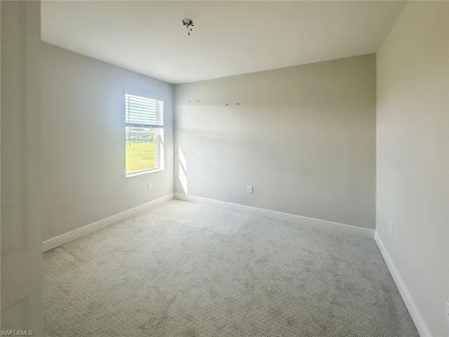 Carpeted spare room with baseboards