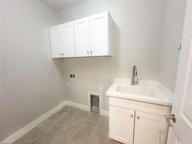 LAUNDRY ROOM featuring washer hookup and cabinet space