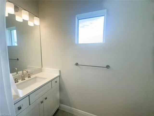 Hallway half Bathroom featuring vanity and baseboards