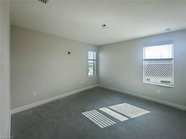 Carpeted spare room with baseboards