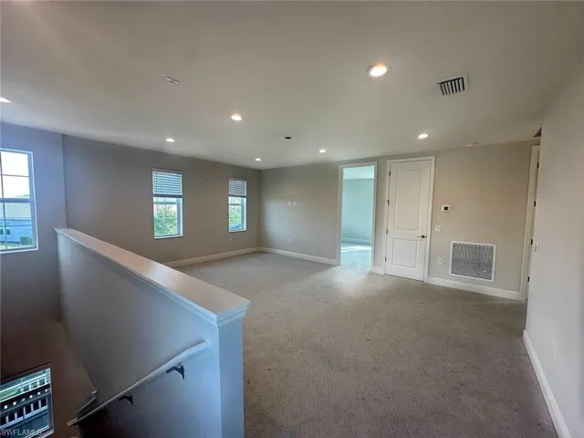 Carpeted empty room featuring recessed lighting and baseboards