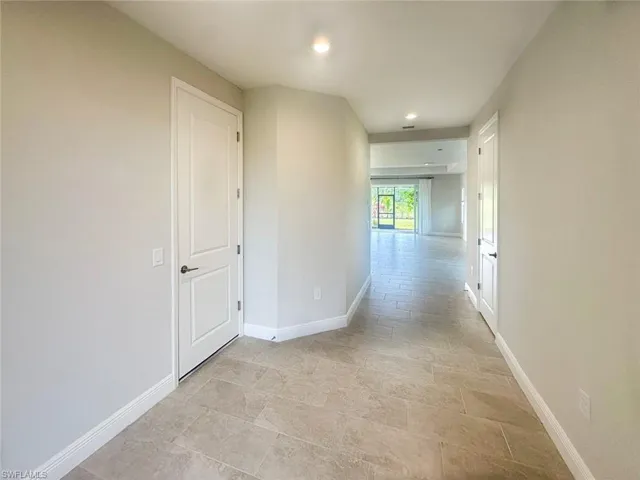 Hall with baseboards and recessed lighting