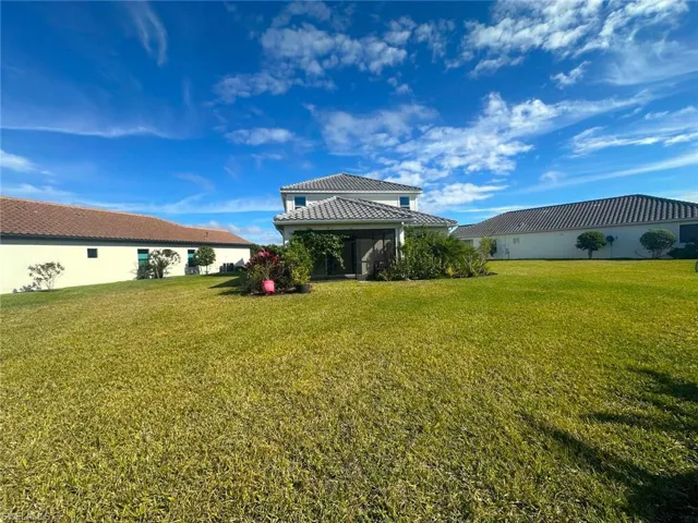 Back of property with a lawn