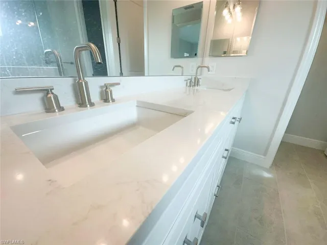 Bathroom featuring double vanity and baseboards