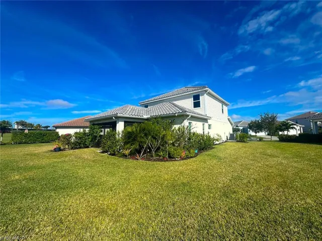 View of side of home featuring a lawn and a tiled roof