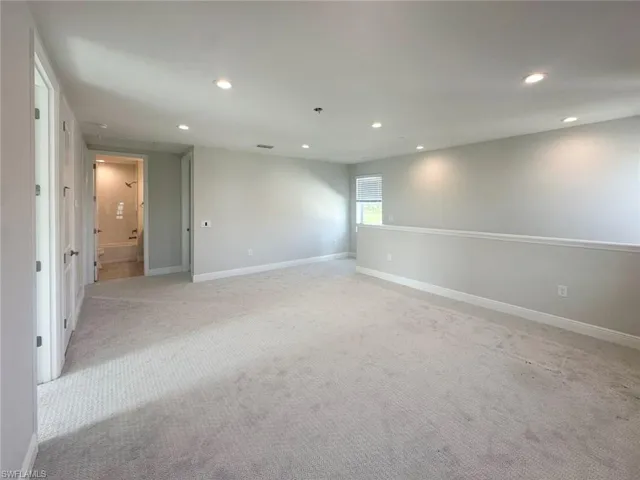 Carpeted empty room featuring baseboards and recessed lighting