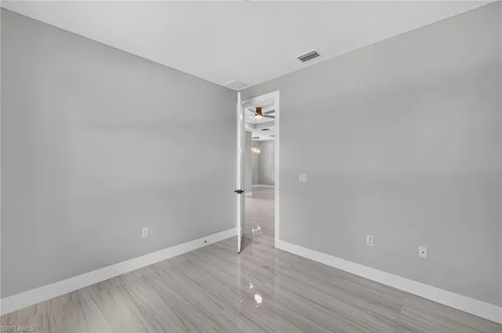 Spacious room featuring light gray walls and white baseboards