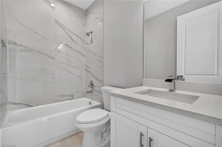 Contemporary bathroom featuring a white bathtub and commode