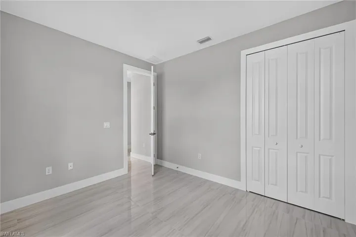 Neutral wall color, white trim, and wood-finish tile flooring