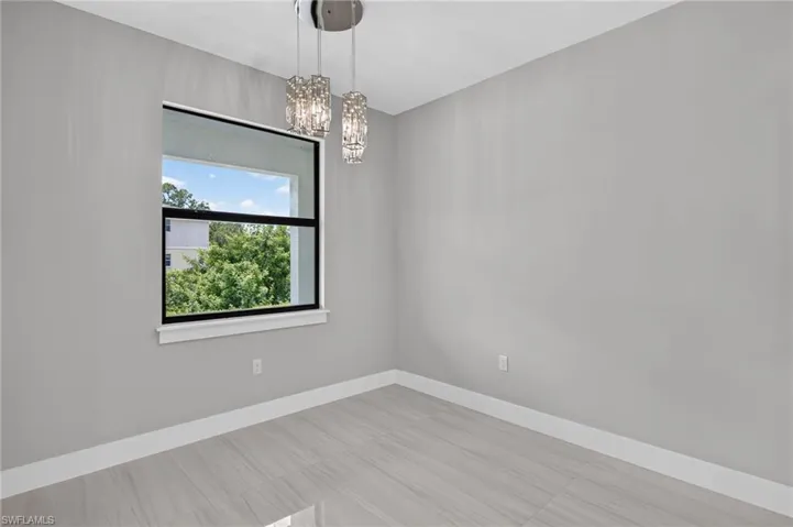 Modern interior space featuring gray walls, white trim, and light-toned tile flooring