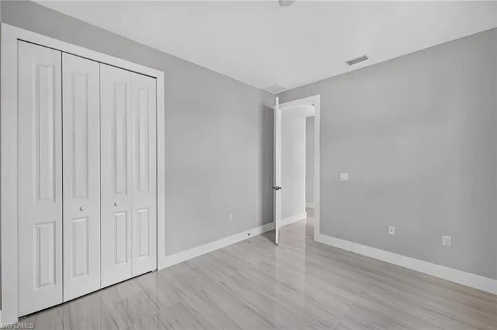 Light grey walls with white trim and multi-panel bifold closet doors