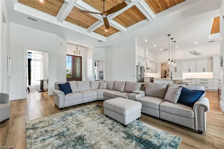 Living room featuring a wood ceiling with exposed beams, coffered ceiling, ceiling fan, light wood-style floors, and recessed lighting