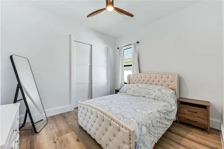Bedroom featuring light wood-style floors, a closet, and a ceiling fan