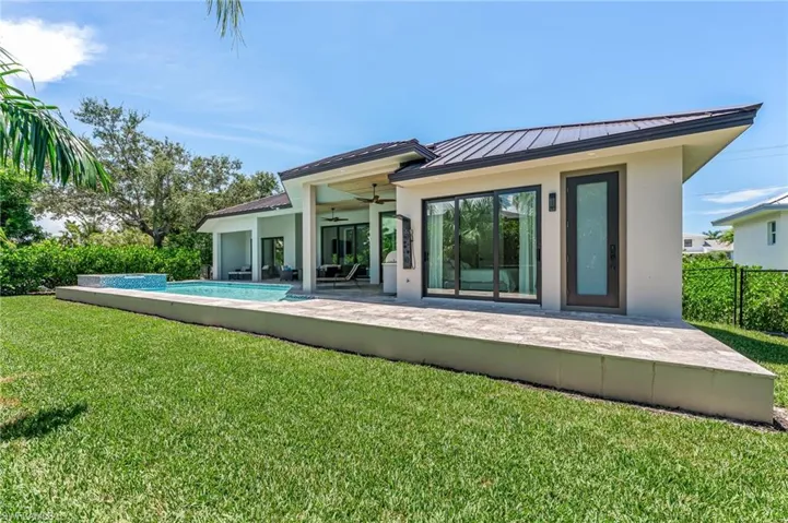 Back of property featuring a ceiling fan, a metal roof, a patio, stucco siding, and a standing seam roof