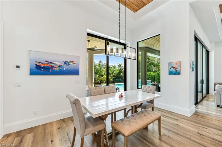 Dining area with light wood-type flooring, a chandelier, and ceiling fan