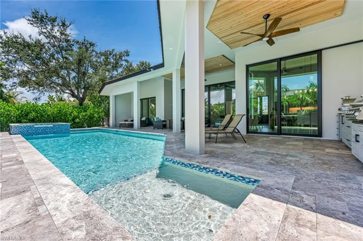 View of swimming pool with a patio, a pool with connected hot tub, and a grill