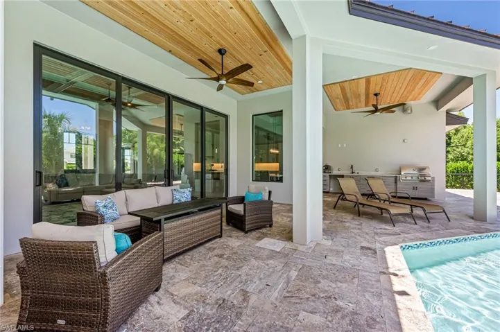 View of patio / terrace with exterior kitchen, ceiling fan, an outdoor pool, and outdoor lounge area