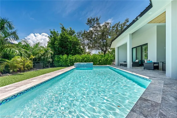 View of pool with a patio, a fenced backyard, an outdoor living space, and a pool with connected hot tub