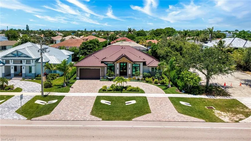 View of front of property featuring decorative driveway, a front lawn, a residential view, and an attached garage
