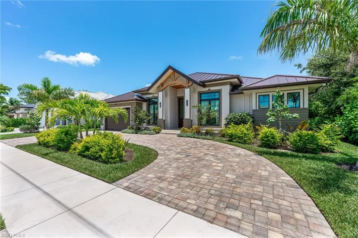 View of front of home featuring a standing seam roof, a metal roof, and decorative driveway