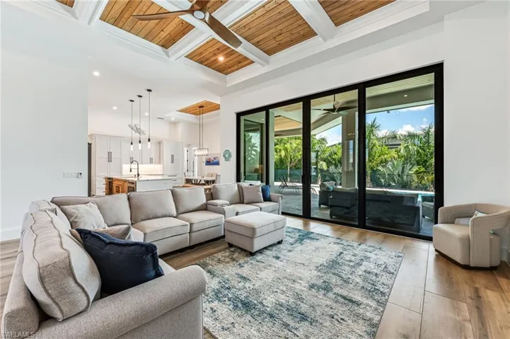 Living room featuring a wood ceiling with exposed beams, coffered ceiling, light wood-style floors, a ceiling fan, and recessed lighting