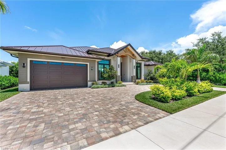 Prairie-style home with decorative driveway, a garage, a metal roof, and a standing seam roof