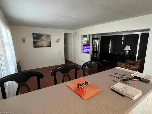 Open concept living area featuring wood-finish flooring, and attached island/bar