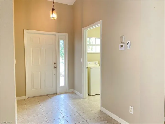 Foyer entrance with washer / dryer and light tile patterned floors