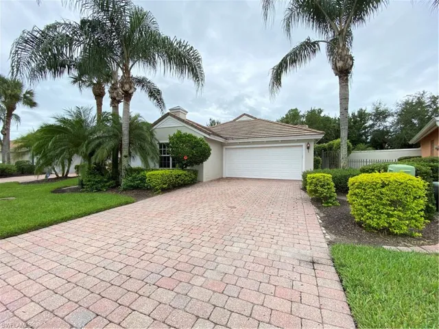 View of front of property with a garage, decorative driveway, and stucco siding
