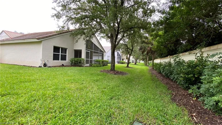 View of yard with a sunroom and glass enclosure