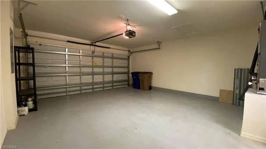 Garage featuring a garage door opener and baseboards