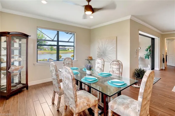 Dining space with light wood-style floors, crown molding, a water view, ceiling fan, and recessed lighting