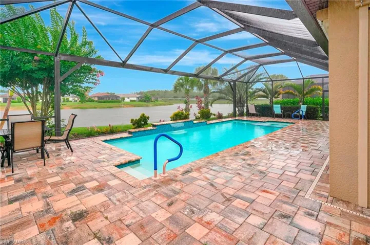 Outdoor pool with a lanai, a patio, a sunroom, and a water view