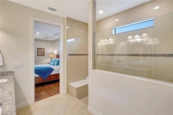 Ensuite bathroom with vanity, a walk in shower, recessed lighting, and wood finished floors