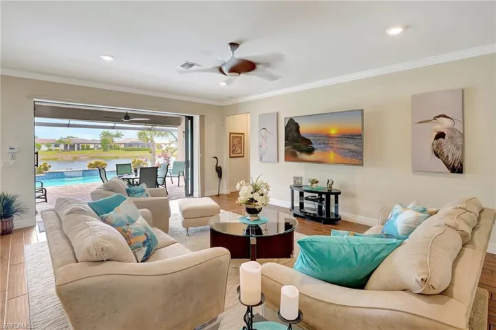 Living area featuring wood finished floors, crown molding, a sunroom, ceiling fan, and recessed lighting
