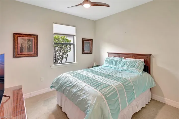 Carpeted bedroom featuring baseboards and ceiling fan