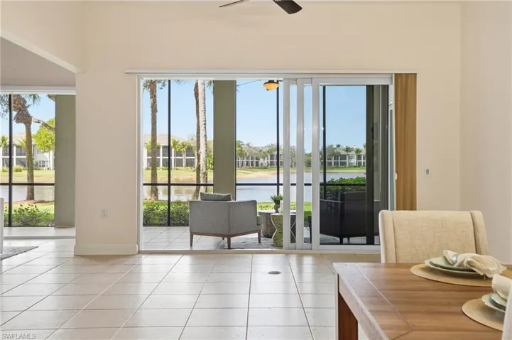 Doorway to outside with a water view, tile patterned flooring, and ceiling fan