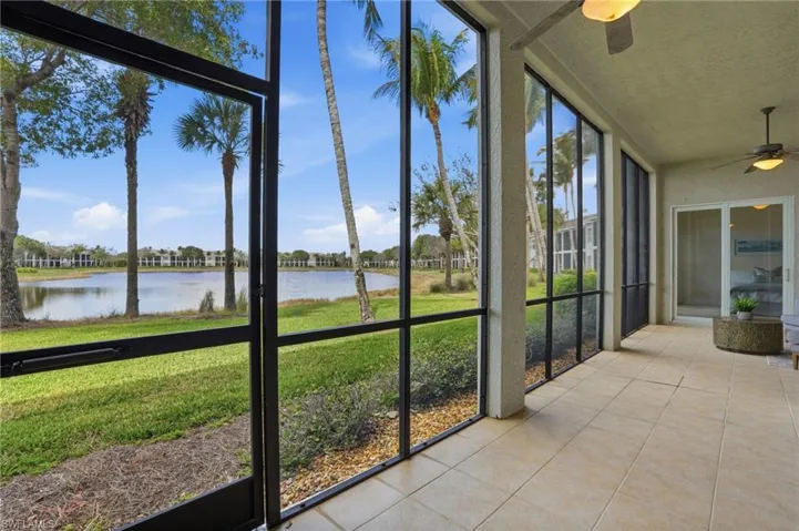 Unfurnished sunroom featuring a ceiling fan and a water view