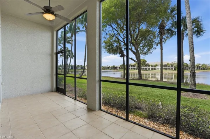 Unfurnished sunroom with ceiling fan and a water view