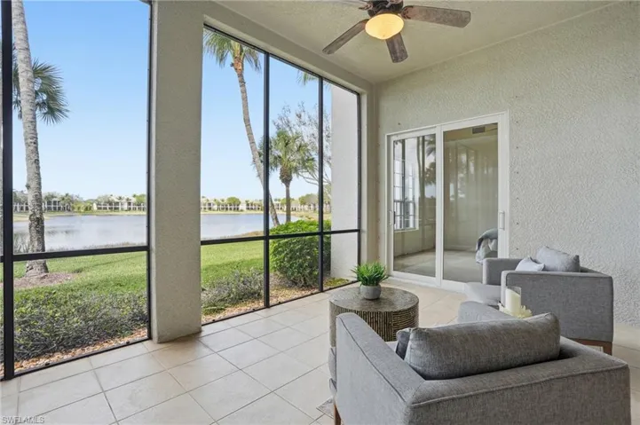 Sunroom featuring a ceiling fan and a water view