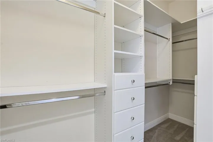 Walk in closet featuring dark colored carpet