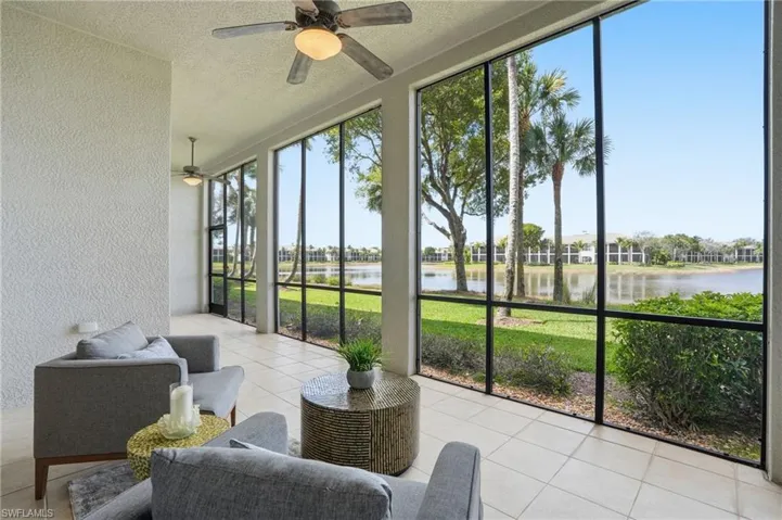 Sunroom featuring a ceiling fan and a water view