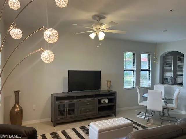 Living area with light tile and a ceiling fan