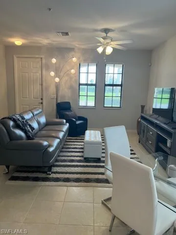 Living area with light tile floors and ceiling fan